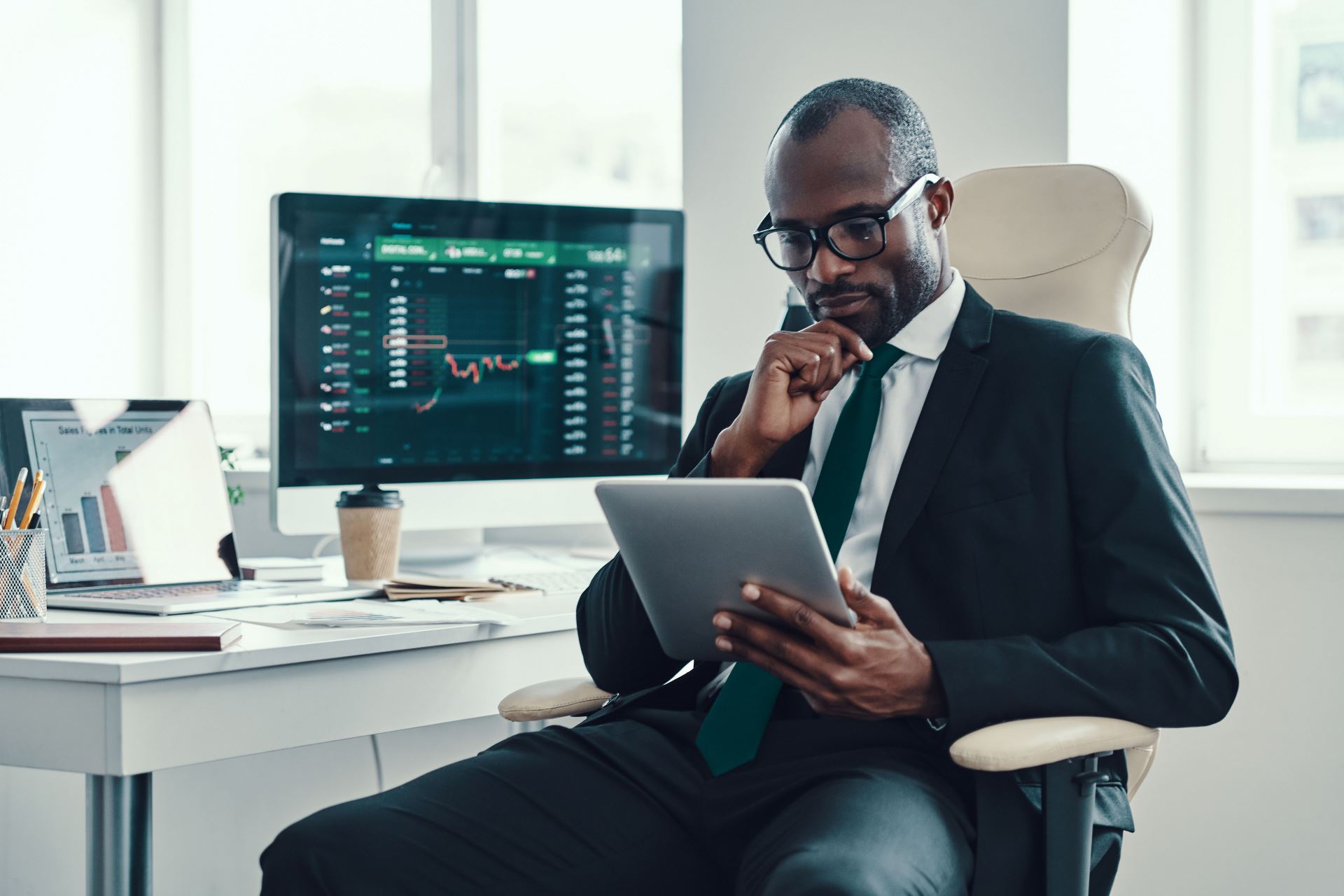 man in his office looking at a tablet