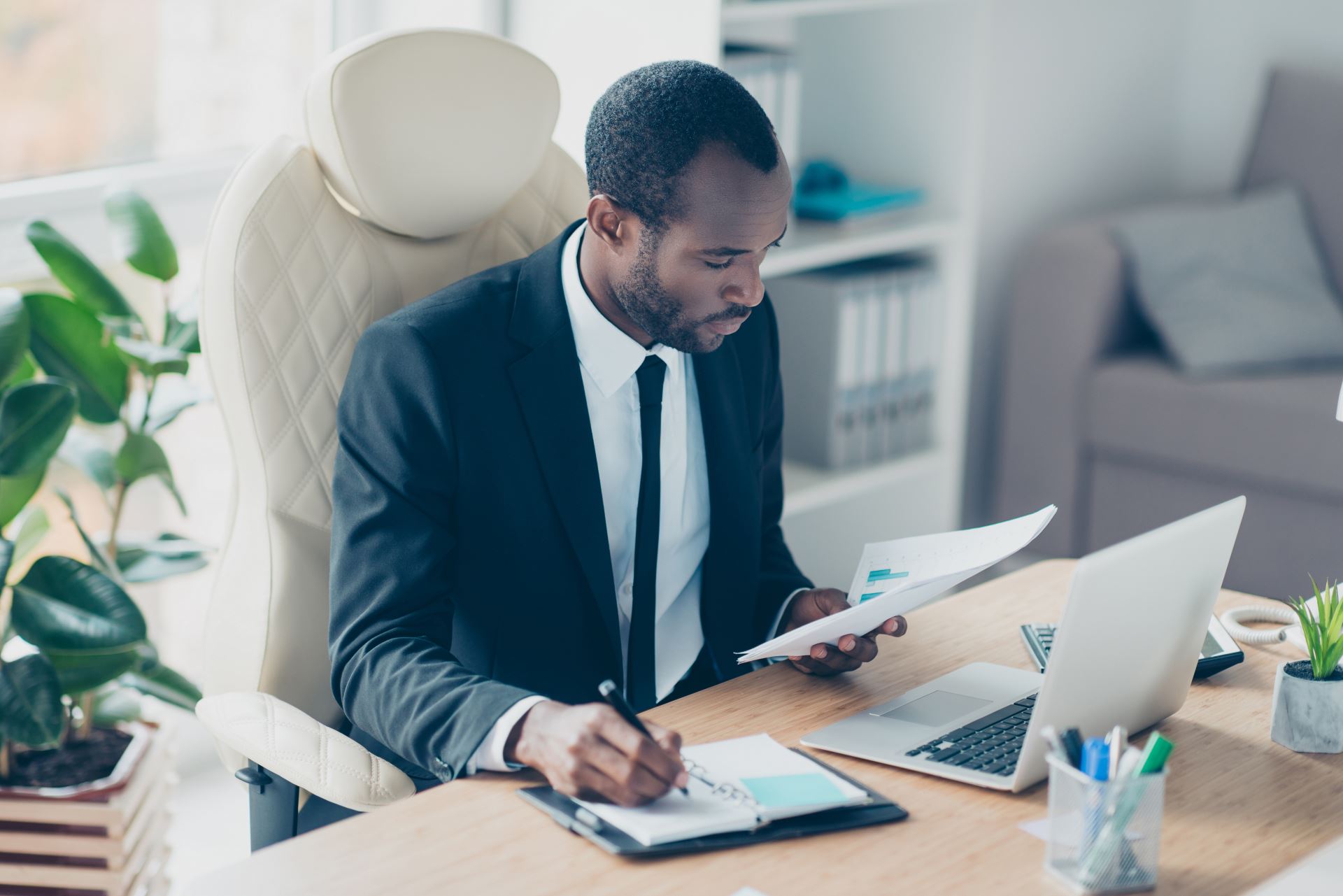 ar forecasting challenges-man sitting at a desk with a laptop holding and reviewing a chart