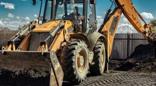 yellow tractor picking up dirt with bucket