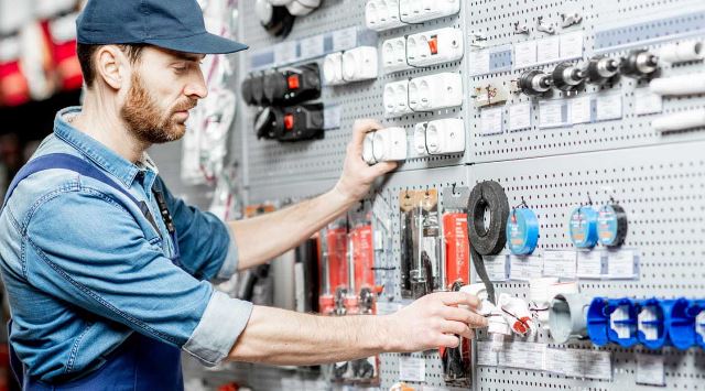 man looking at a wall of hardware supplies