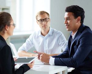 Three professionals having a discussion around a table