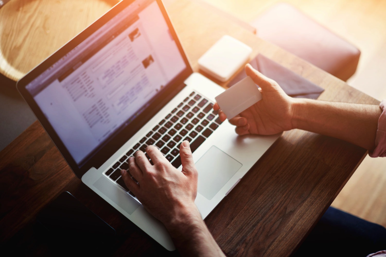 person paying bill on laptop holding credit card