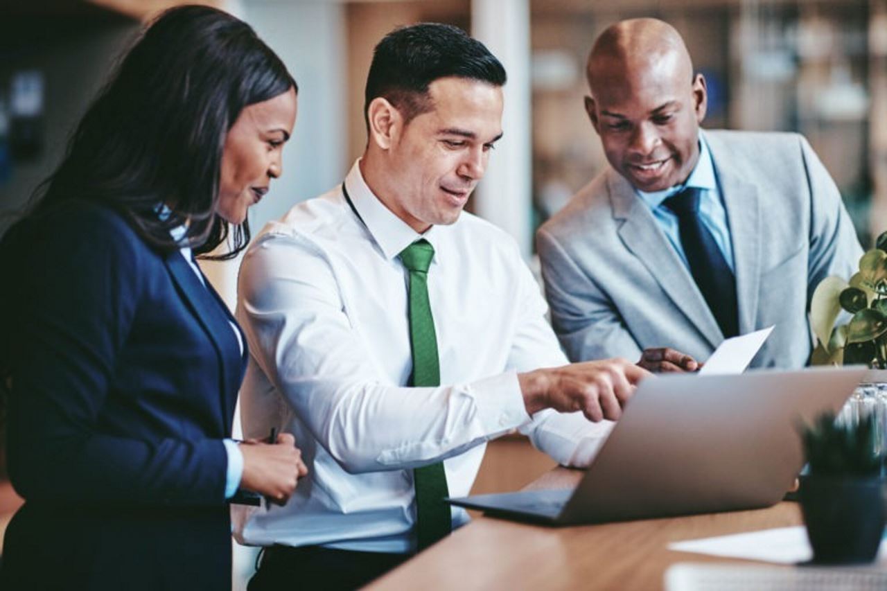 employees having a meeting and looking at a laptop