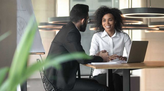 Man and woman working at laptop together